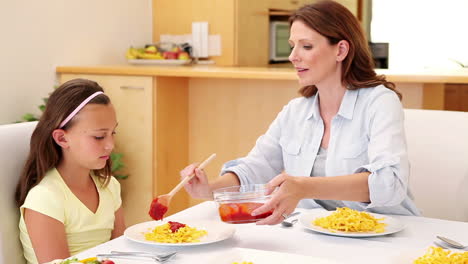 Smiling-mother-serving-her-daughter