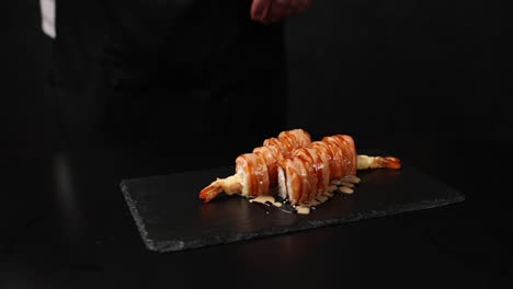 el chef preparando un rollo de camarón tempura