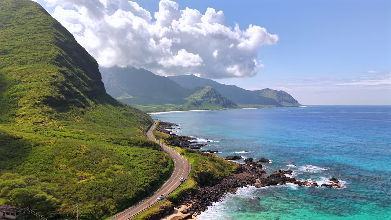 Winding highway on the Waianae coast with mountains and the sea, aerial