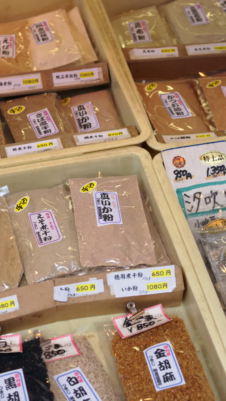 Multiple bags of spices for sale at the Tsukiji Fish Market in Japan. Vertical. Translation: "Condiment names"