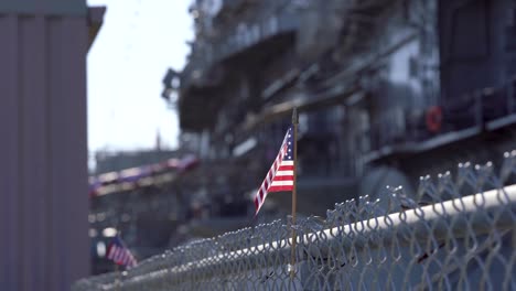 american flag in front of old wwii era warship