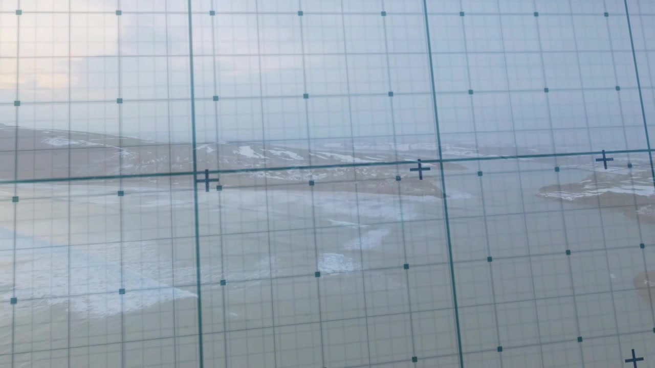 Camera panning and tilting causing teal grid film sliding over hazy coast stabilizing to align