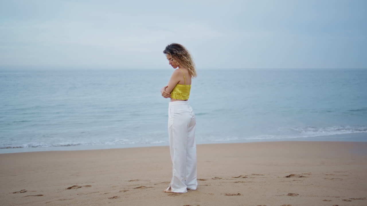 외로운 소녀는 바람이 불고 있는 해변을 생각하고, 아름다운 바다 풍경을 혼자 즐기고 있다.