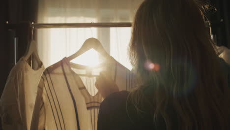 Silhouette-of-a-woman-choosing-her-clothes-in-the-rays-of-the-setting-sun