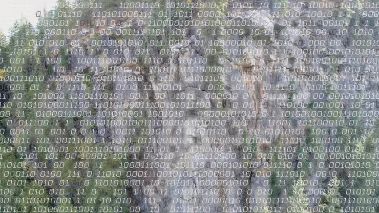 Acercamiento de la cámara a un acantilado vertical que está siendo escaneado, superposición binaria que aparece en la base mapeando los datos