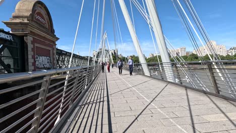 pedestrians crossing a bridge in london, england