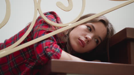 frustrated woman burnouts on steps closeup. pretty lady with ptsd symptoms lies on staircase at home. young woman loses interest in living after trauma