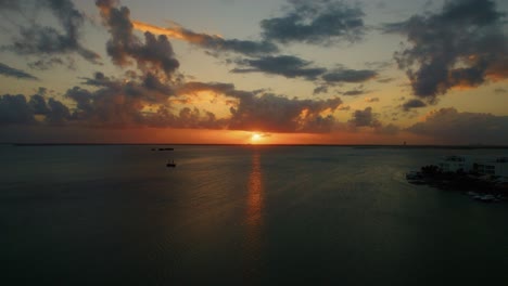 Sonnenlicht-Am-Strand-Von-Cancun,-Das-Sich-Auf-Dem-Karibischen-Meer-Mit-Fahrenden-Booten-Bei-Sonnenuntergang-Spiegelt