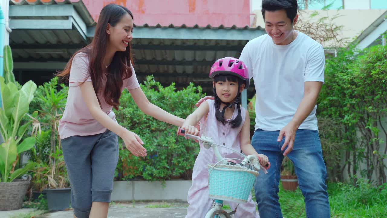 아이에게 자전거를 타는 법을 가르치는 가족