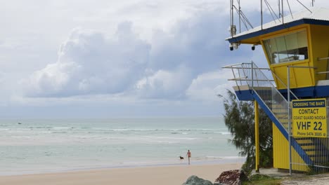 people enjoying a sunny beach day near lifeguard tower