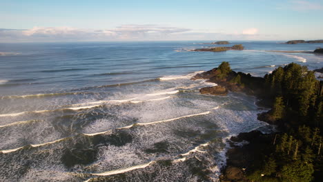 Waves-run-out-onto-rugged-rocky-and-forested-Tofino-coastline,-BC