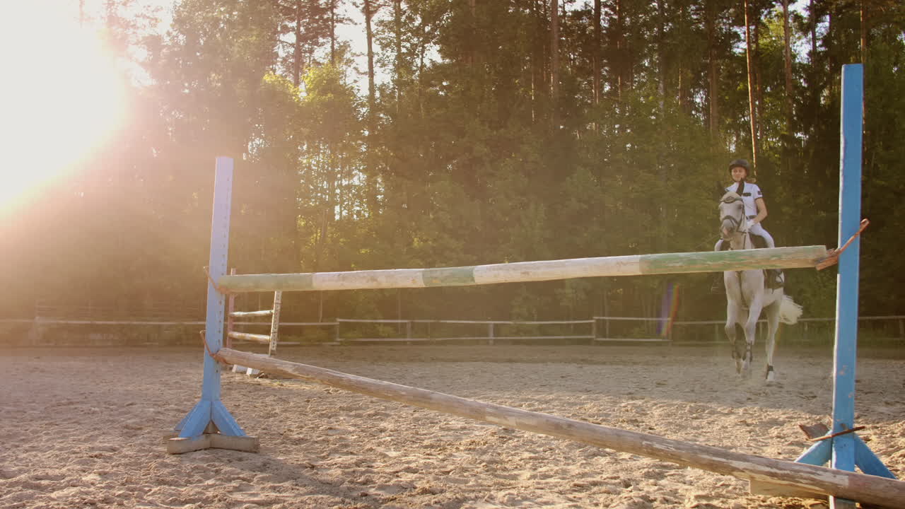 The girl demonstrates skills in jumping with a horse over an obstacle.