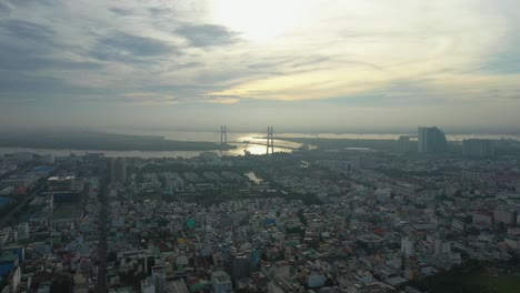 fly in over urban area towards river and large modern suspension bridge in early morning light part one