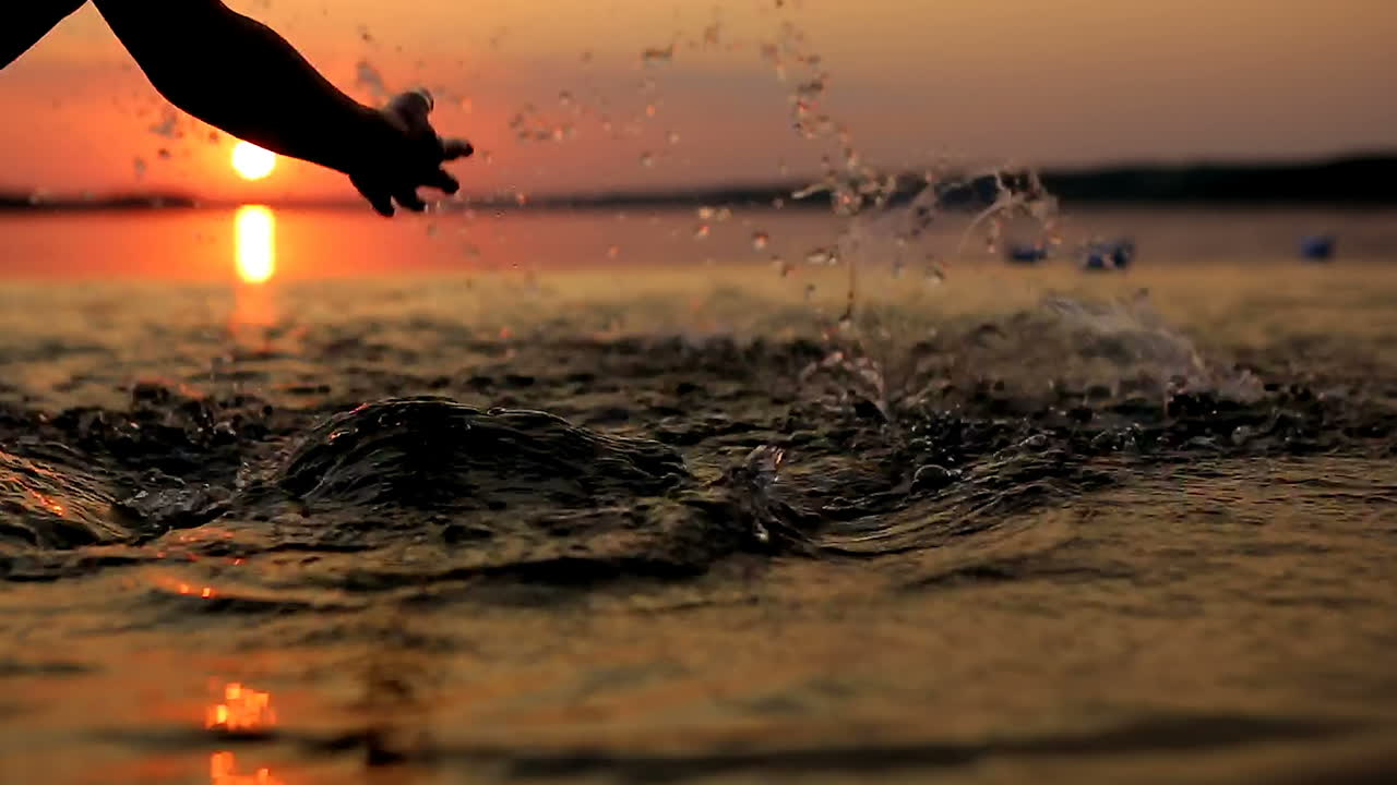 Boy Launching Paper Boat. Little boy launching paper boat on water from beach