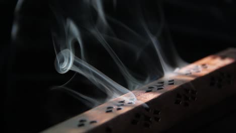 el tiempo retrocede mientras el humo del incienso se enrosca en un quemador de incienso de madera