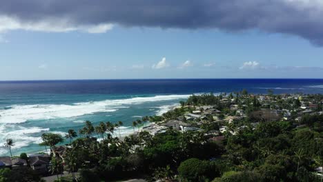 aerial view of a tropical coastline with residential area and ocean waves