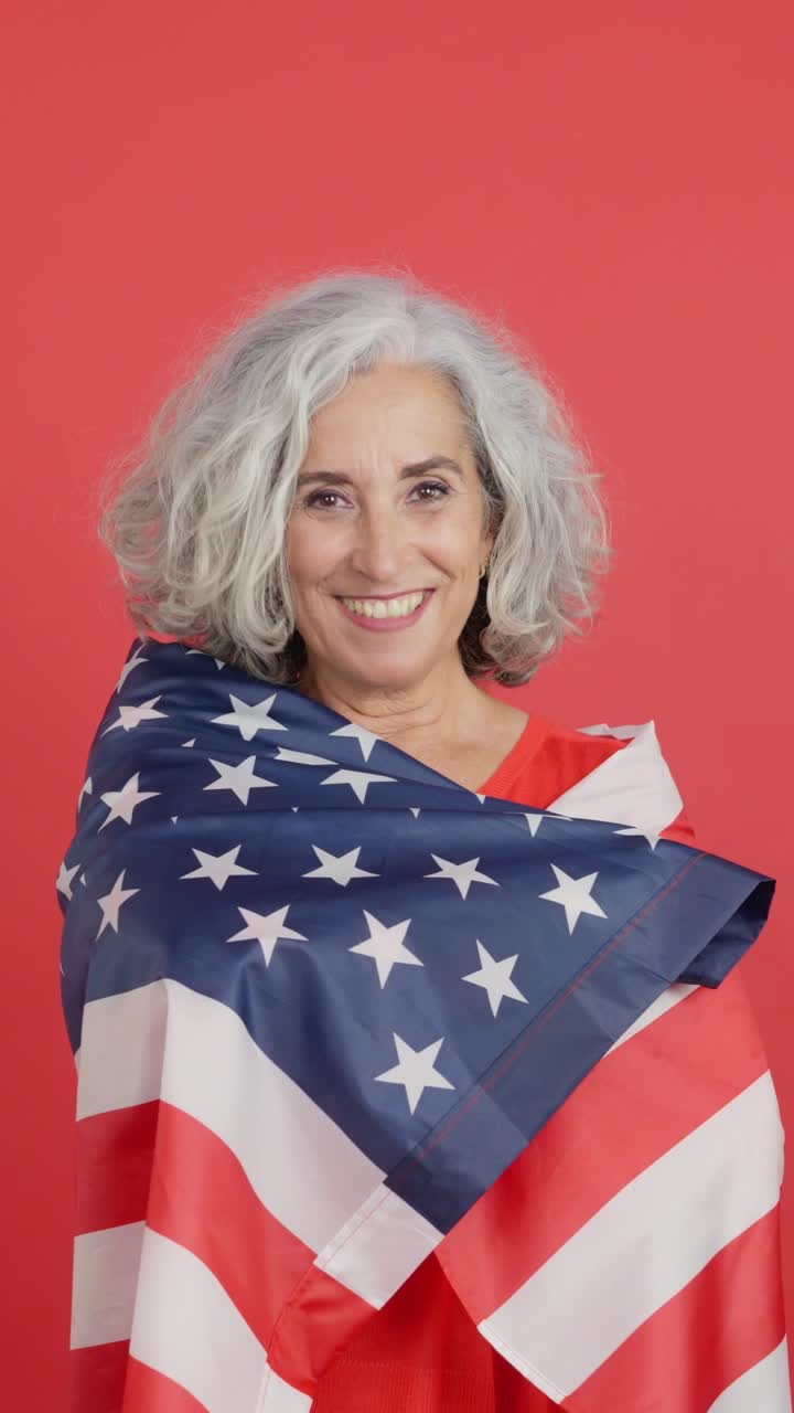Donna anziana sorridente avvolta nella bandiera americana