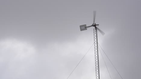 residential wind turbine system spinning on a cloudy day