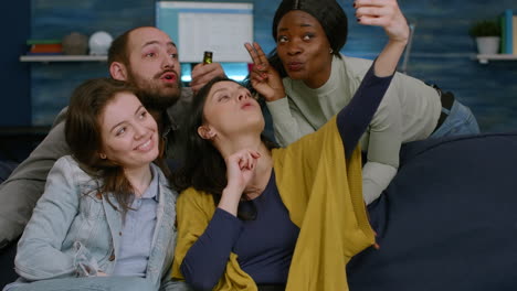 multiracial friends taking sefie together using smartphone posting on social media