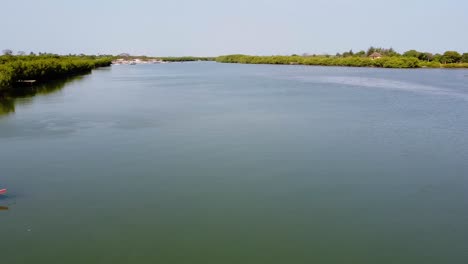 Pan-across-boat-on-river-Gambia-shores-and-wide-open-waterway-near-kartong