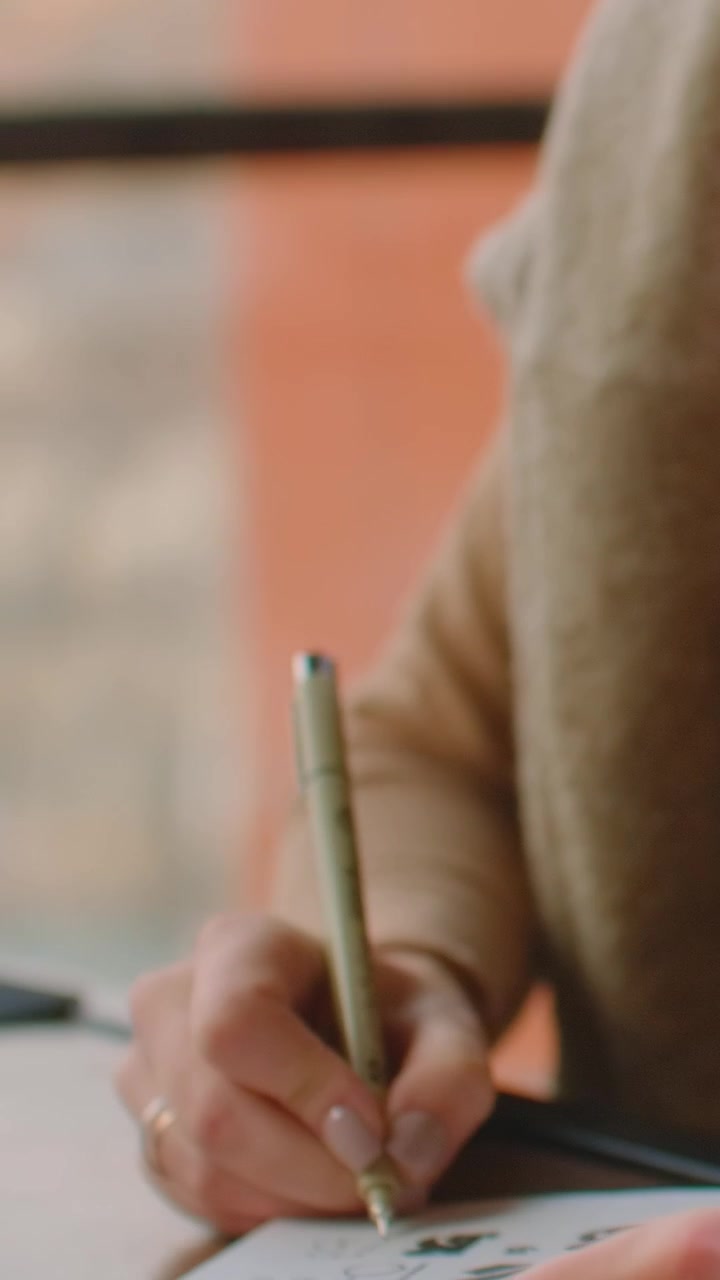 Young Woman Drawing Sketches in a Notebook