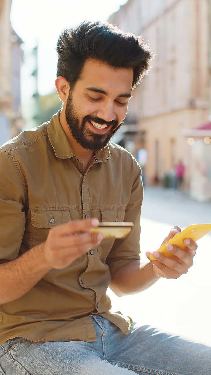 Indian man using credit bank card smartphone while transferring money purchases online shopping