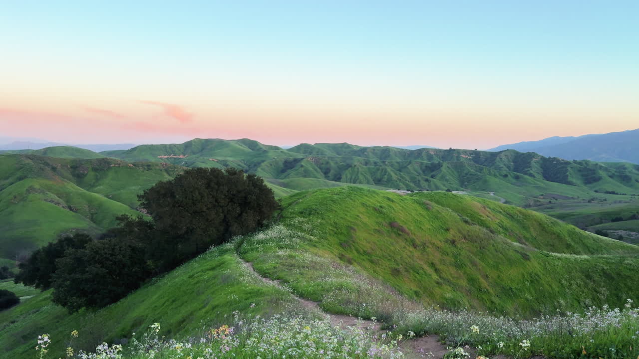 Pemandangan indah perbukitan hijau bergelombang dan jalur setapak saat matahari terbenam di Chino Hills State Park, latar belakang alam, lanskap California, dan gaya hidup luar ruangan.