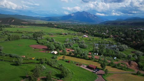 spring creek ranch mt sopris carbondale roaring fork river aspen snowmass summer aerial drone colorado june july rocky mountain snow cap peaks marble el jebel marble basalt clouds sunny forward pan up