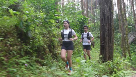 couple trail running in forest