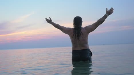 hombre mayor en el agua estirando las manos