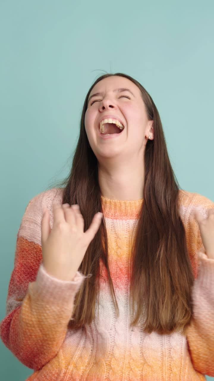Joyful woman laughing and smiling in colorful sweater
