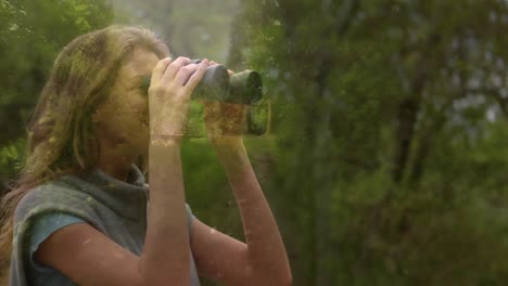 woman observing the forest using binoculars