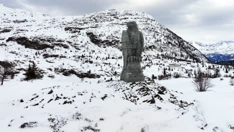 águila escultura de piedra en el paso de simplon con en el fondo los altos alpes suizos cubiertos de nieve