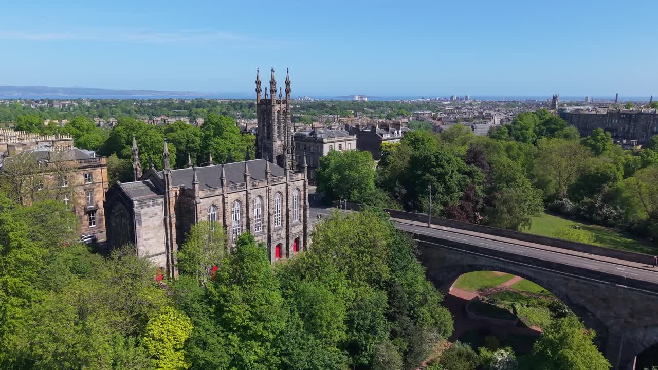 Drone orbit around a gothic church and Dean Bridge in Edinburgh, revealing the stunning cityscape and architectural harmony from above
