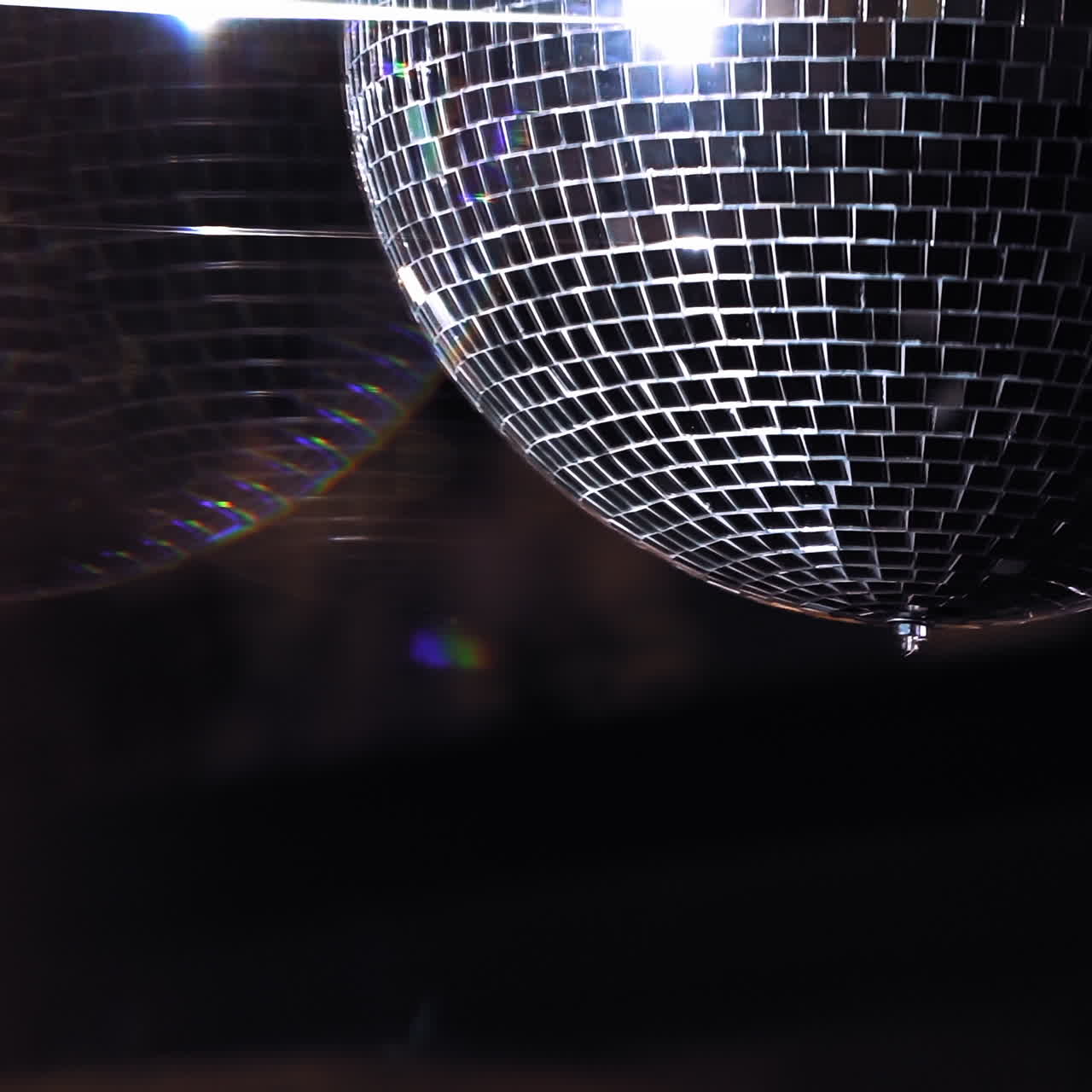 Disco ball is spinning. Round mirror ball reflecting real club lights and lasers. Evening party. Reflection of light. Lighting device.
