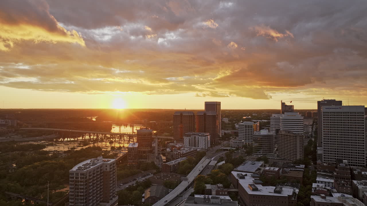 Sobrevoo aéreo v100 de Richmond, Virgínia, sobre Shockoe Bottom, capturando a paisagem urbana do centro à beira do rio ao pôr do sol, com um brilho dourado refletindo no rio James - Filmado com Mavic 3 Pro Cine - 30 de setembro de 2023