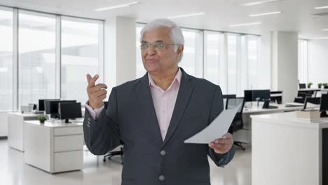 un gerente senior indio feliz discutiendo informes con los empleados