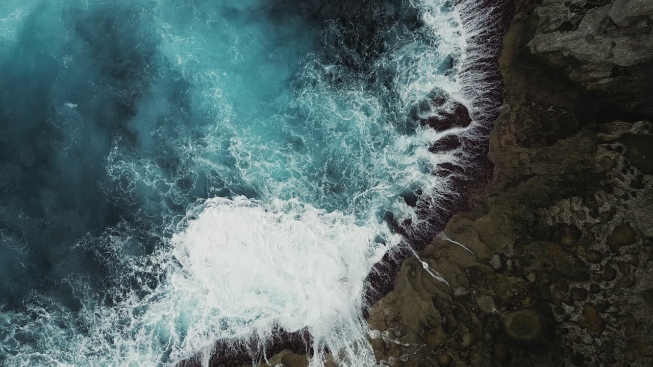 Aerial View of Ocean Waves Crashing on a Rocky Coast