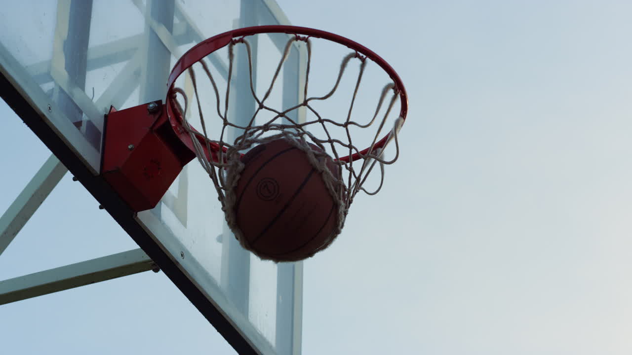 bola de baloncesto lanzada con éxito a la canasta en el patio de recreo deportivo.