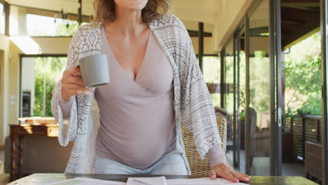 happy caucasian pregnant woman with cup of tea making video call