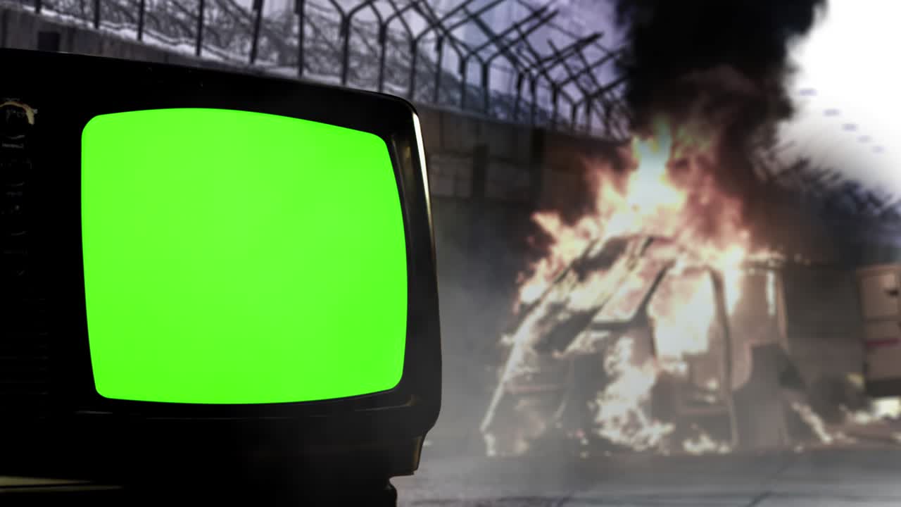 거리와 오래된 텔레비전 그린 스크린에서 폭동 불꽃은 가시선 울타리와 녹색 스크린의 레트로 tv 세트와 함께 벽 근처에 불타는 밴에서 상승.
