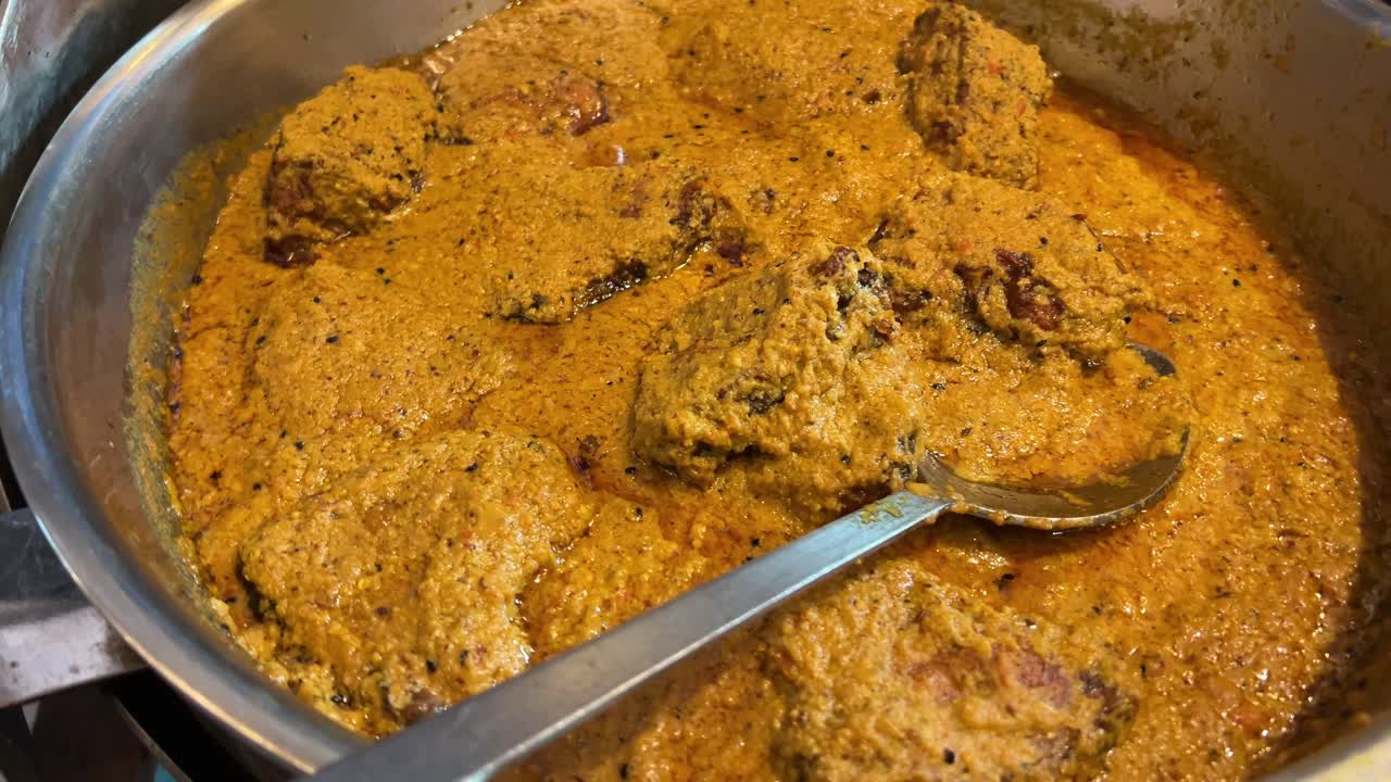 bandeja con pescado katla con salsa de consistencia gruesa y una espátula de metal para servir. cocina bengalí.