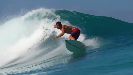 man surfing a large blue ocean wave