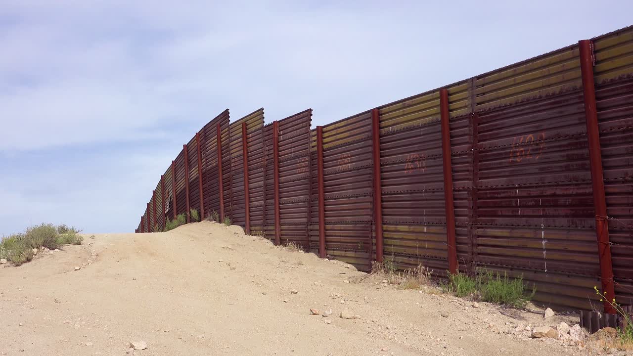 la cerca del muro fronterizo entre estados unidos y méxico rueda sobre una pequeña colina