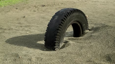 old car wheel buried in sand. sliding with keeping eye on tire.