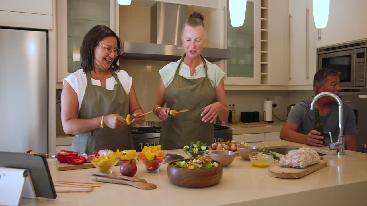 Diverse group of diverse seniors cooking together in modern kitchen, enjoying conversation, at home