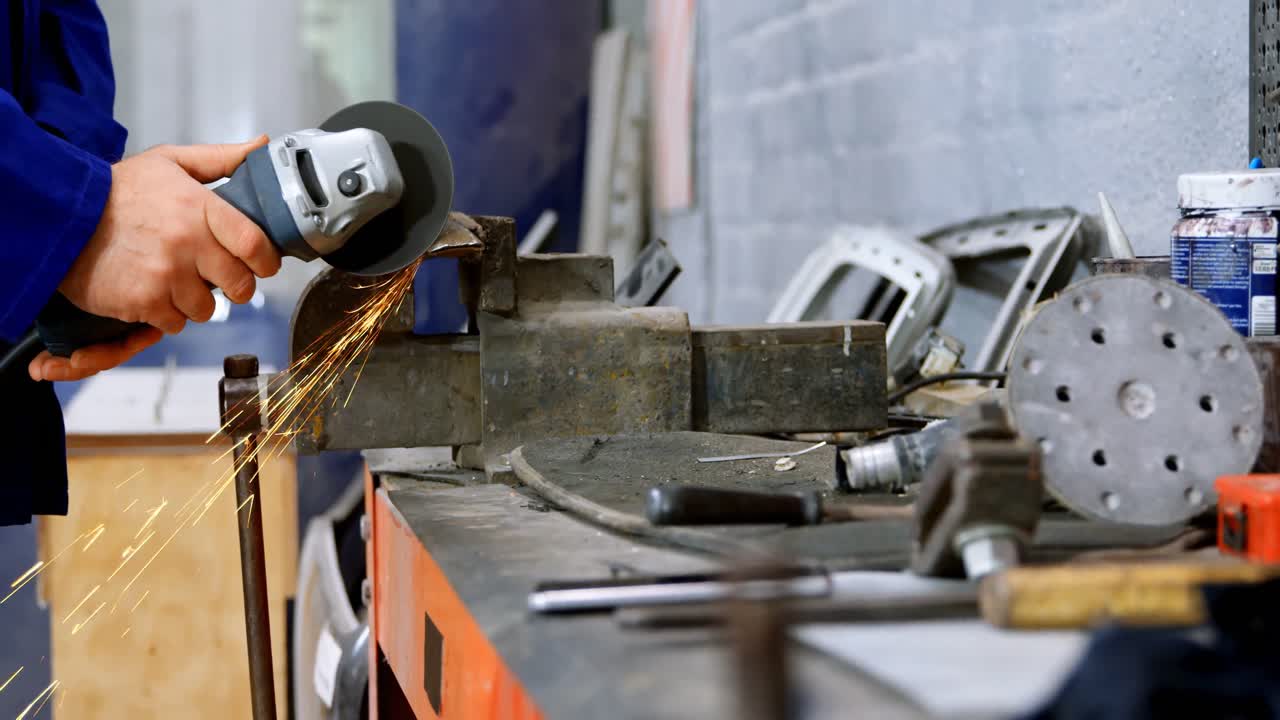 mecánico que usa una máquina de rectificar en el garaje 4k