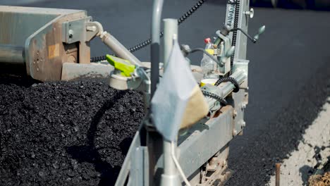 road machinery for leveling the ground passes the road under the supervision of workers. close-up