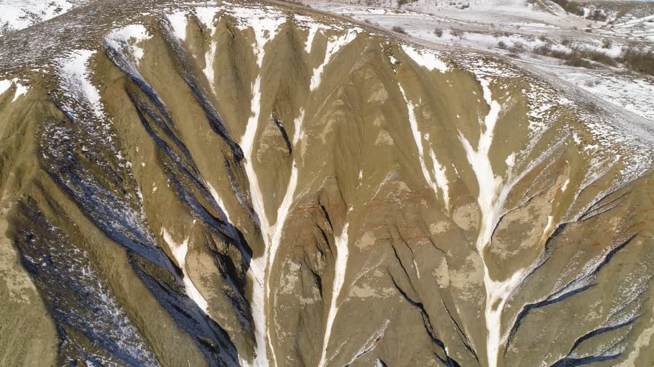 paisaje montañoso nevado con patrones de erosión