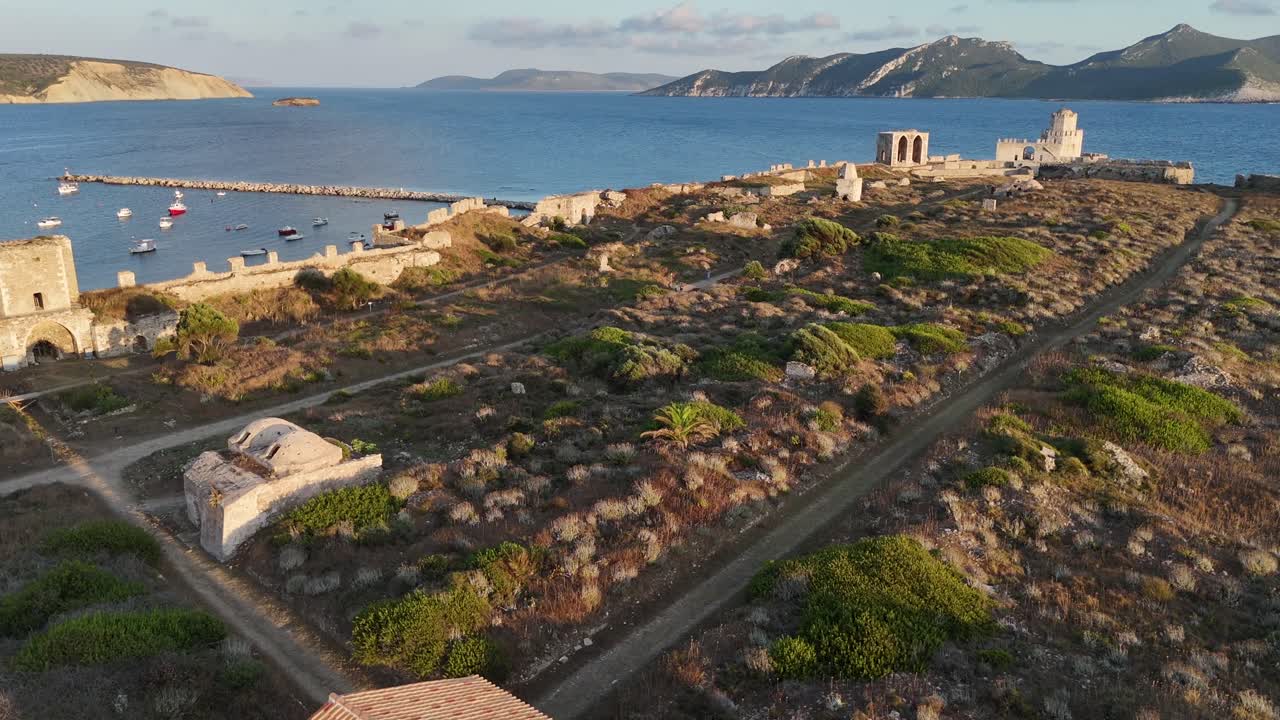 Methoni,Messenia,Peloponnese,Aerial view forward over Methoni Castle towards the sea,circle pan left around the Castle tower.Background are hills and beautiful landscape during golden hour